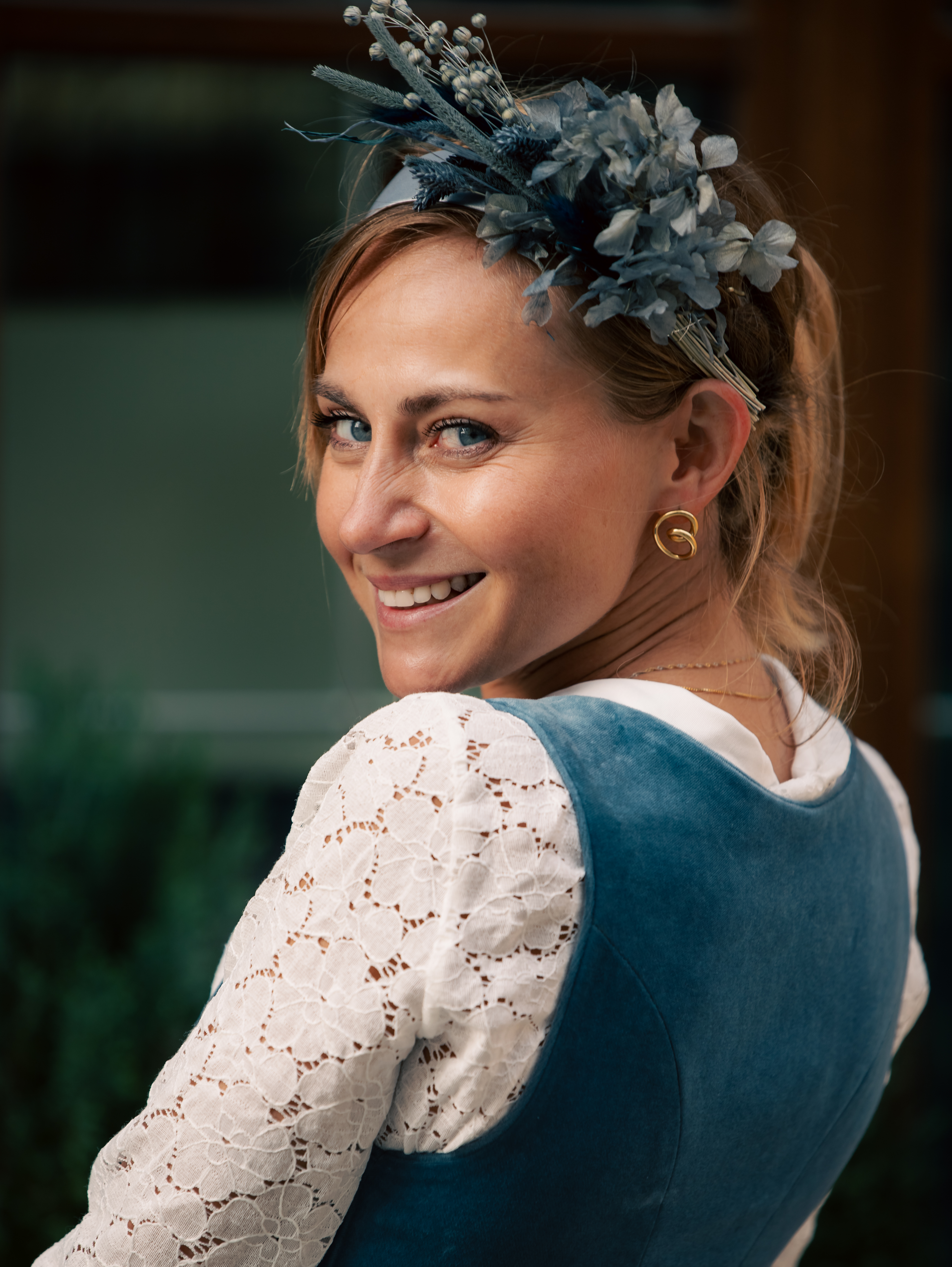 Portrait of a smiling woman with floral headpiece.